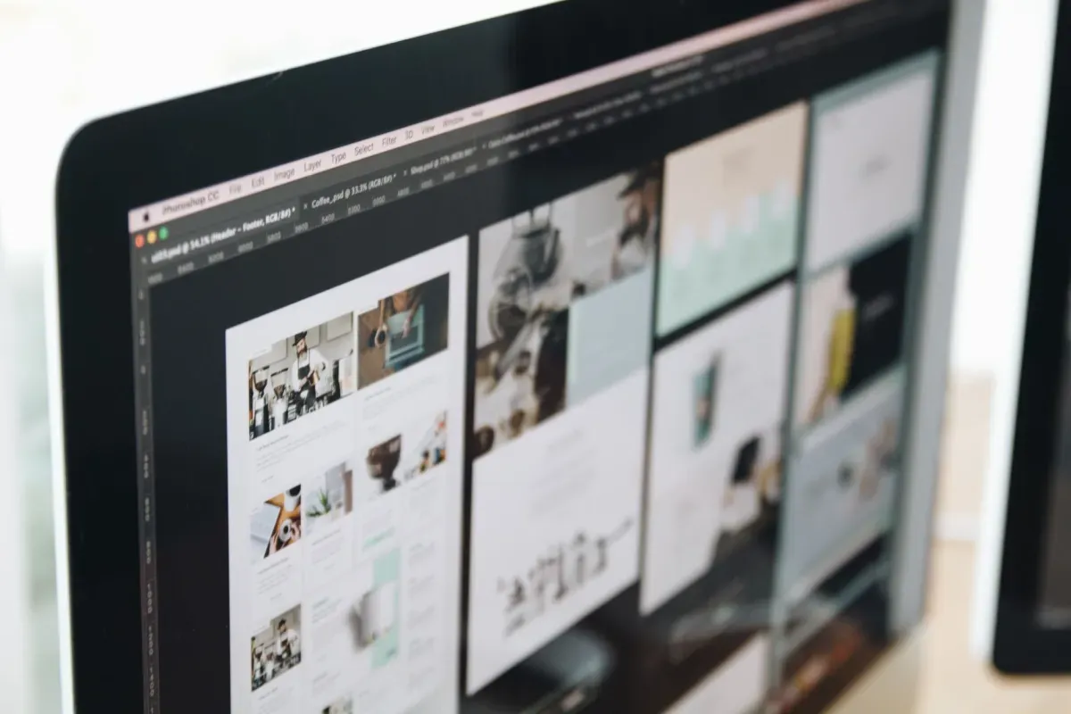 Monitor exibindo layouts de páginas de um site em edição