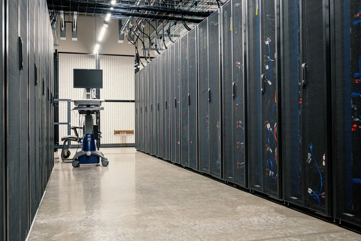 Corredor de um data center com fileiras de armários de servidores dos dois lados